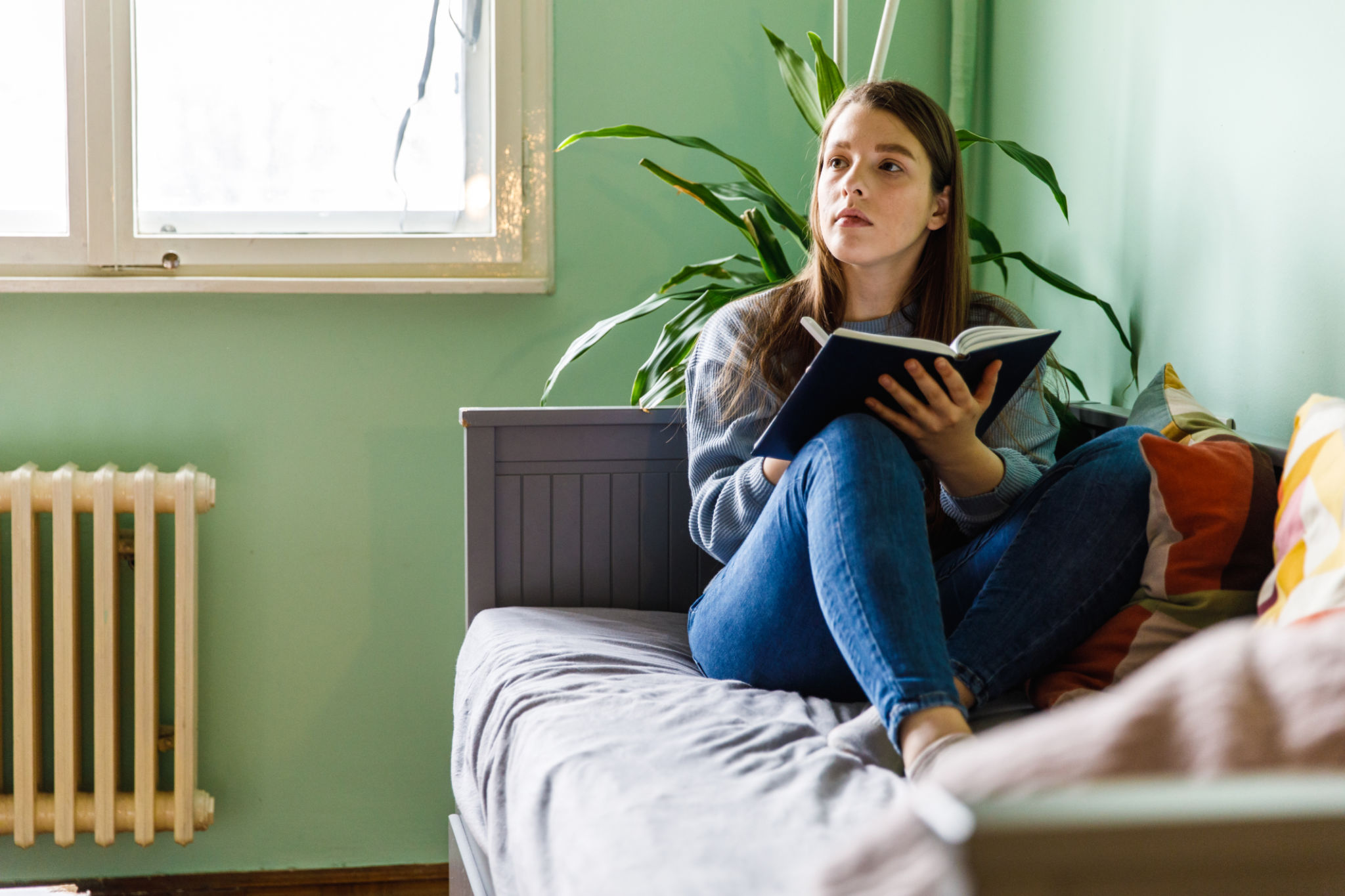 Woman reflecting while writing in a journal